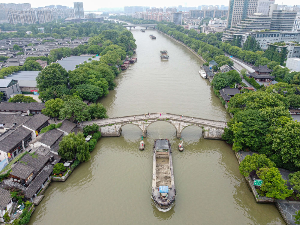 5月27日，一艘貨船駛過京杭大運河南端標志建筑杭州拱宸橋。(無人機照片)新華社記者江漢 攝