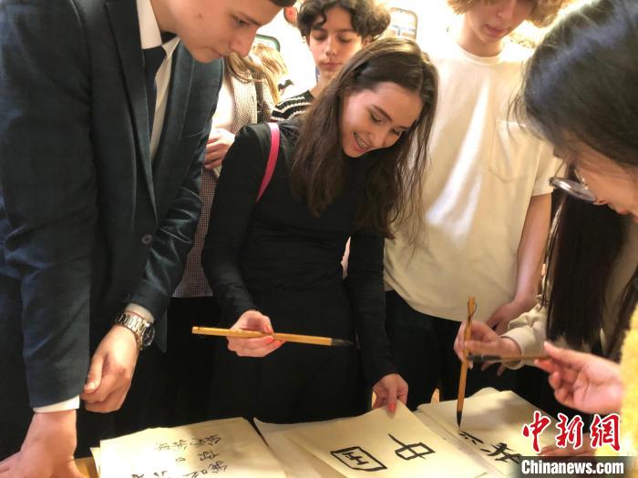 4月21日，莫斯科國立語言大學孔子學院附屬中學舉辦“國際中文日”活動，學生們學寫漢字。　莫斯科國立語言大學孔子學院 供圖