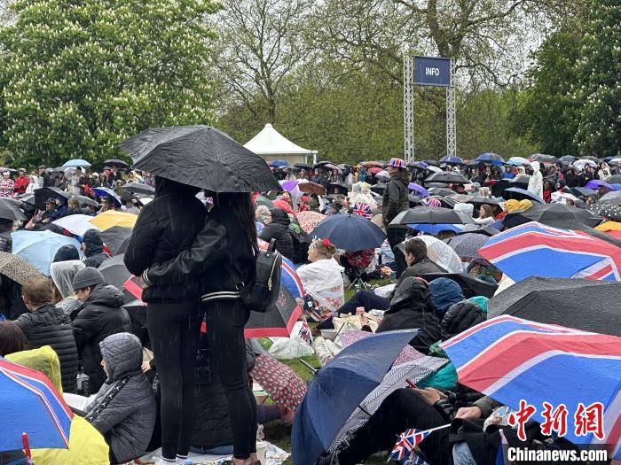 當?shù)貢r間5月6日，英國國王查爾斯三世的加冕儀式舉行。民眾雨中觀看儀式。　歐陽開宇 攝
