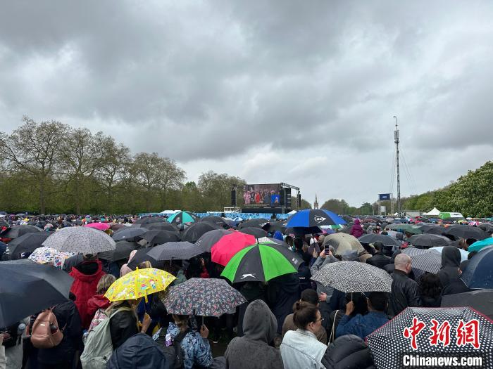 當?shù)貢r間5月6日，英國國王查爾斯三世的加冕儀式舉行。民眾雨中觀看儀式。　歐陽開宇 攝