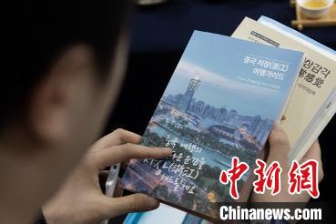 參展觀眾閱讀浙江文旅手冊?！《≌裾?攝