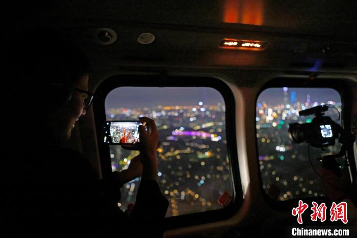 6月3日晚，游客乘坐上海新空直升機有限公司直升機開啟鳥瞰黃浦江空中圓夢之旅，并用手機拍攝城市夜景?！∫罅⑶?攝