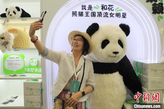 美國華視總裁楊蓮花與大熊貓文創產品合影。　王磊 攝