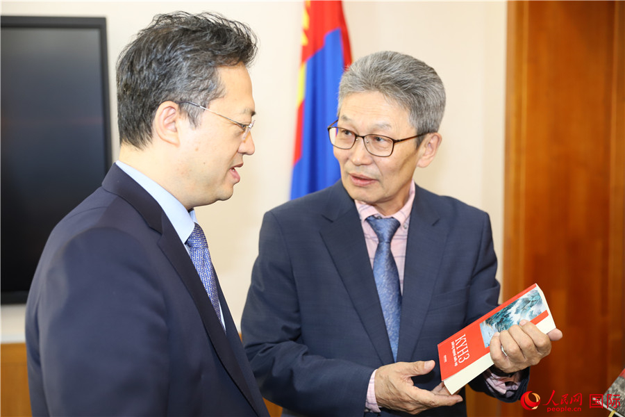 其米德策耶（右一）向李峙介紹翻譯成果。人民網記者 霍文攝