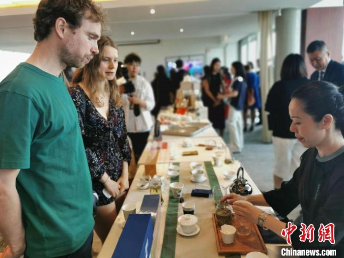 現場觀眾觀看中國展臺茶藝表演、了解茶文化。　靖樹 攝