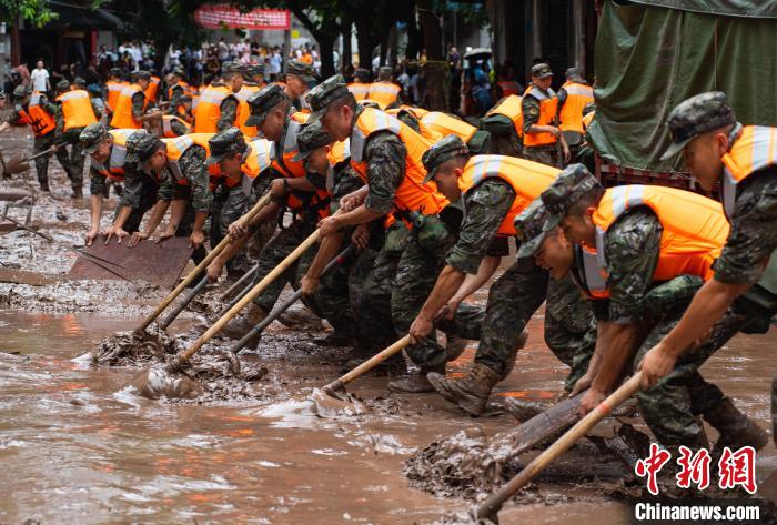 7月4日，萬州區五橋街道，武警官兵清理街道上的淤泥。　冉孟軍 攝