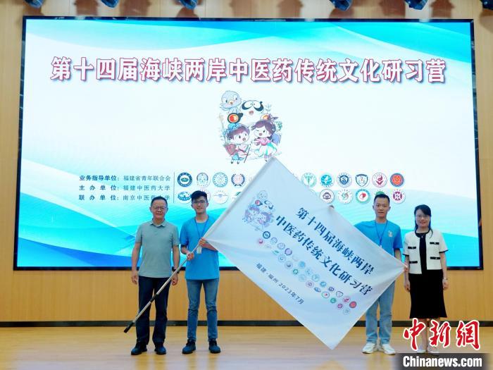 共青團(tuán)福建省委副書記吳雪(右一)、福建中醫(yī)藥大學(xué)黨委副書記林羽(左一)為兩岸學(xué)生代表頒授營(yíng)旗。　許燁婷 攝