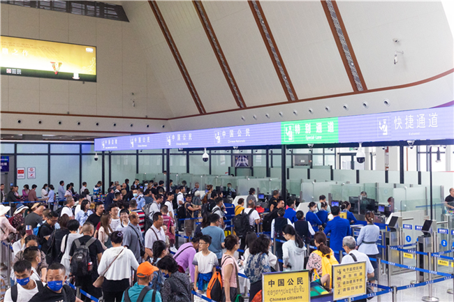 7月22日，乘坐中老鐵路國際旅客列車的旅客在磨憨邊檢大廳排隊候檢。衛海林 攝