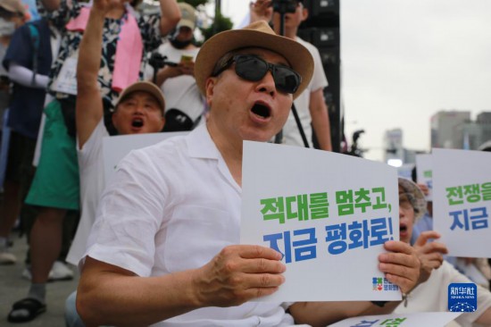 7月22日，在韓國(guó)首爾，人們手舉標(biāo)語(yǔ)參與反戰(zhàn)游行。新華社發(fā)（楊暢 攝）