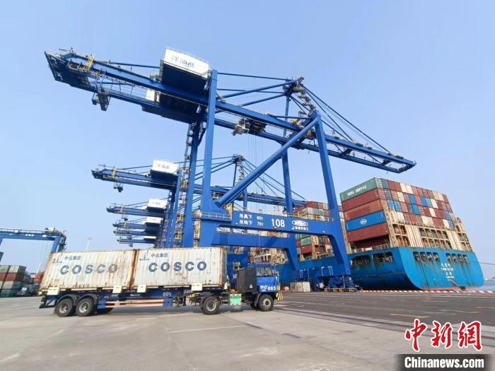 圖為海南洋浦國際集裝箱碼頭，卡車將集裝箱從后方堆場運(yùn)往碼頭裝卸區(qū)。　張?jiān)潞?攝