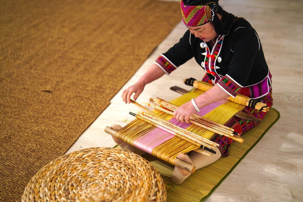 4月17日，黎族傳統(tǒng)紡染織繡技藝國(guó)家級(jí)代表性傳承人劉香蘭在2023年意大利米蘭設(shè)計(jì)周上展示黎錦織造技藝。新華社發(fā)