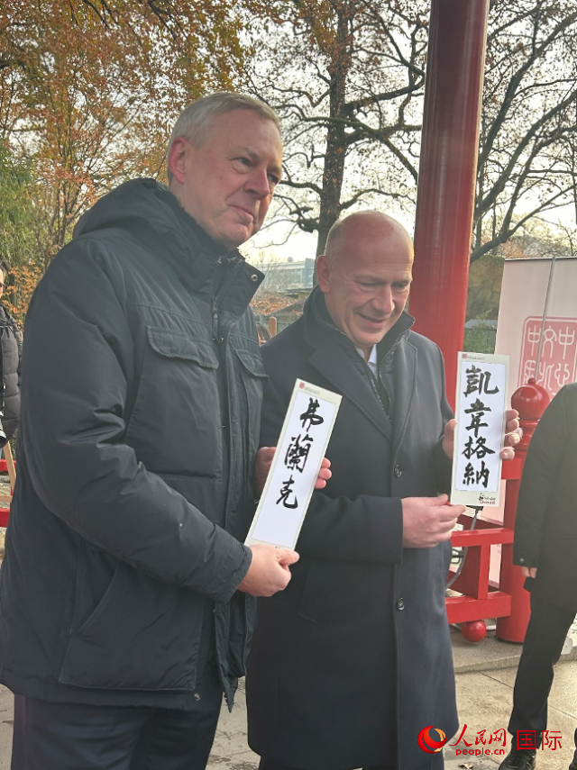 柏林市長韋格納（右）、動物園監(jiān)事會主席布魯克曼（左）手持中國文化中心工作人員現(xiàn)場手書的中文名字。人民網(wǎng)記者 徐馨攝