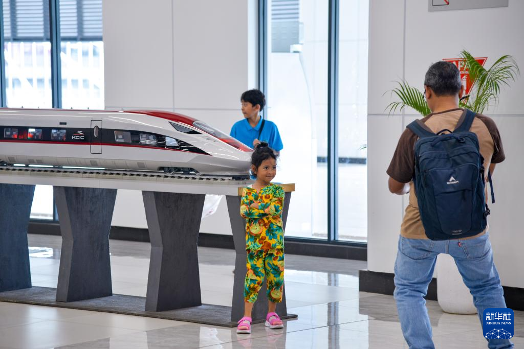 1月24日，在印度尼西亞雅加達(dá)哈利姆站候車大廳，一名小朋友和雅萬高鐵高速動車組模型合影。新華社記者 徐欽 攝