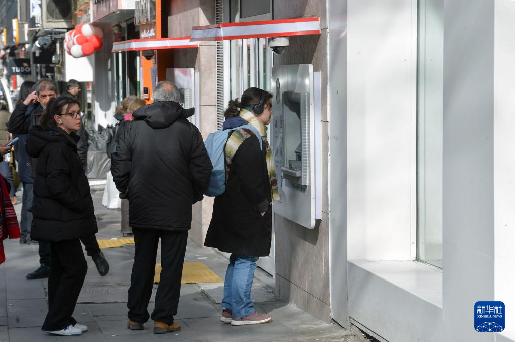 1月25日，人們在土耳其安卡拉一處銀行自動柜員機前辦理業務。新華社發（穆斯塔法·卡亞攝）