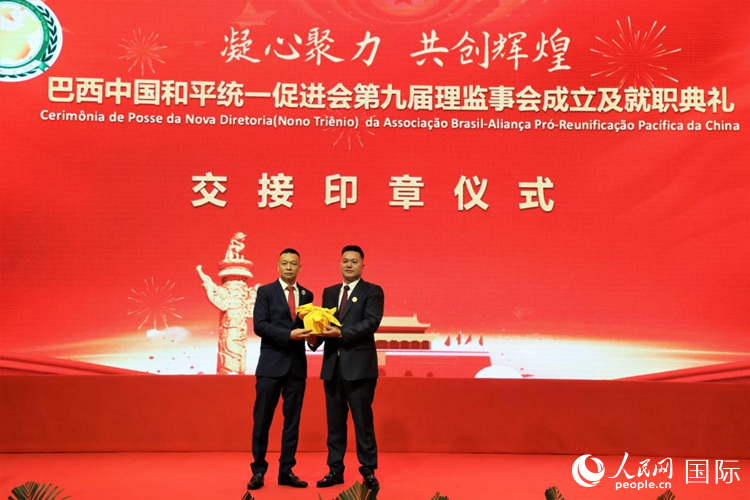 就職典禮中，巴西和統會第七屆和第八屆會長王俊曉與新任會長張小春交接印章。人民網記者 時元皓攝