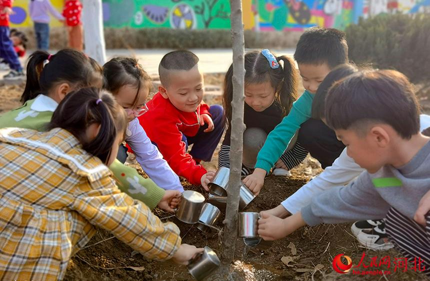 河北省東光縣小朋友們一起給小樹們澆水。 陳英華攝