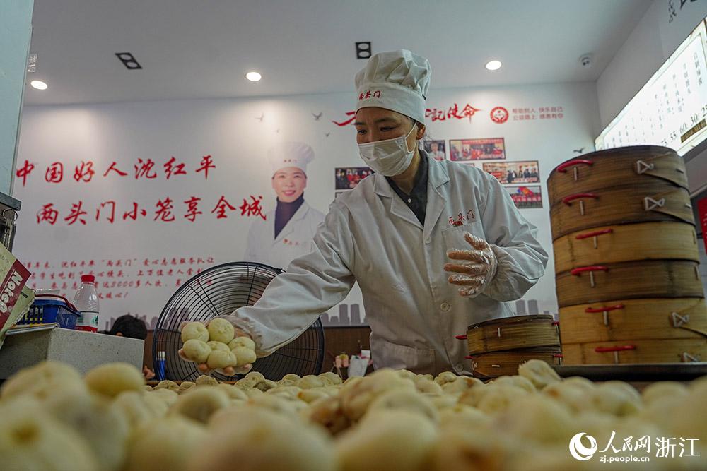 3月31日，在浙江省嵊州市甘霖鎮(zhèn)，嵊州小吃從業(yè)者沈紅平把蒸熟的小籠包晾涼，打包冷藏售賣。人民網(wǎng) 章勇濤攝