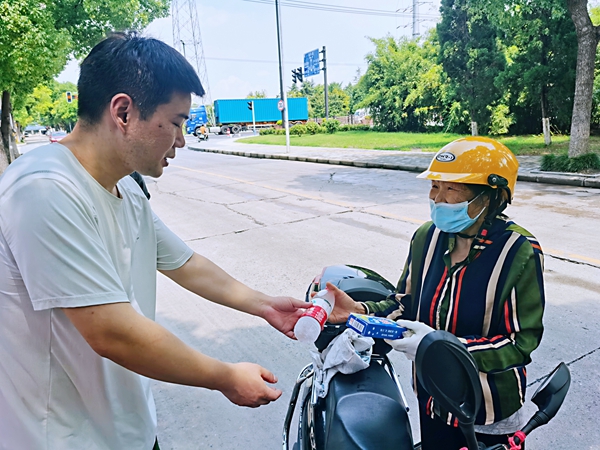 何超為過路的老人送上礦泉水和冷飲。人民網記者 王繼亮攝