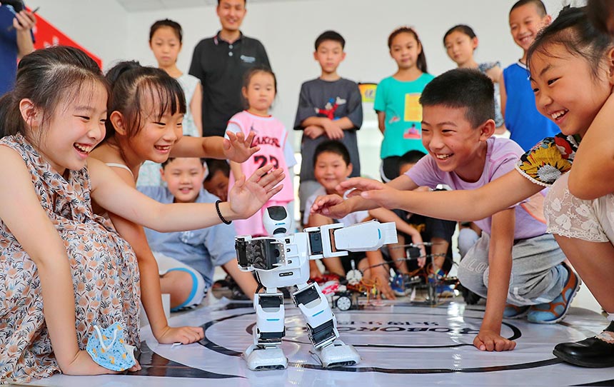 2022年7月19日，河北省秦皇島市海港區白塔嶺街道秦皇半島第二社區內，小朋友正在觀看“機器人跳舞”。 曹建雄攝