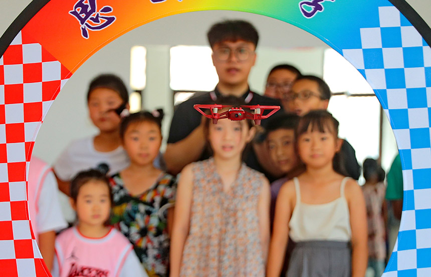  2022年7月19日，河北省秦皇島市海港區(qū)白塔嶺街道秦皇半島第二社區(qū)內(nèi)，小朋友正在觀看“無(wú)人機(jī)穿越飛行”。 曹建雄攝