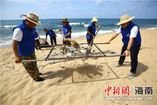 環(huán)保志愿者用篩網(wǎng)“淘”出海灘上的垃圾。