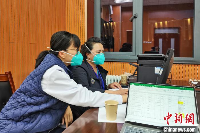 8月9日，楊蘇喬(左)在拉薩方艙醫院指揮部讀取艙內患者胸部CT。　受訪者供圖