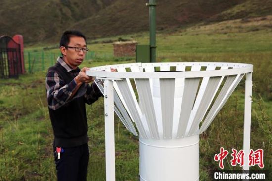 圖為班瑪縣氣象局工作人員在維護藏雪茶基地氣候站。青海省氣象局供圖
