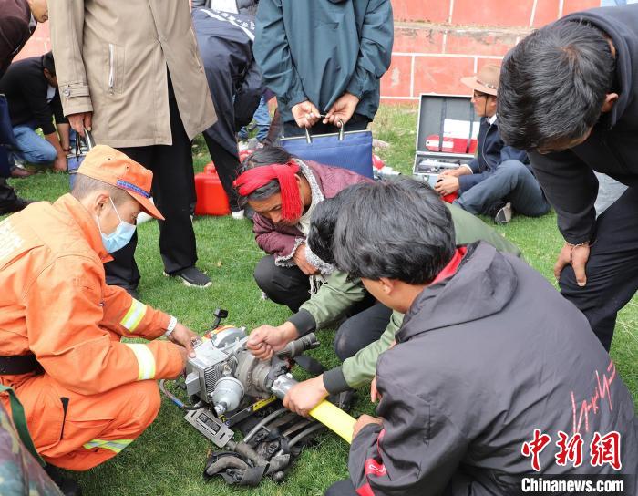 圖為森林消防員為護林員講解滅火裝備的使用方法?！〔际猩窒乐ш?供圖