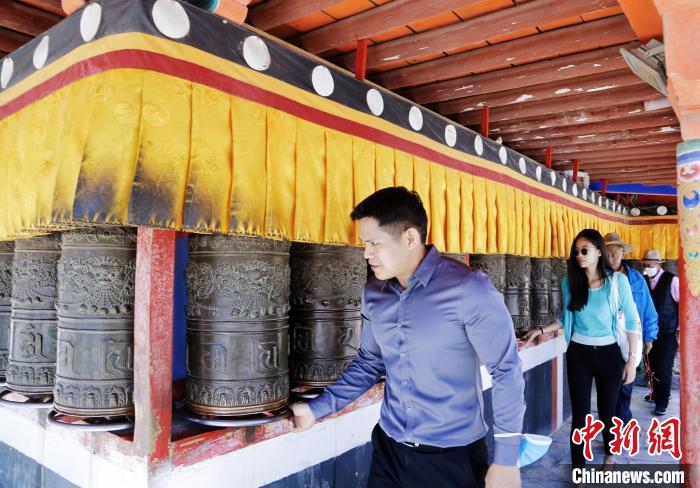圖為外籍嘉賓體驗藏族傳統(tǒng)轉經(jīng)筒。　馬銘言 攝