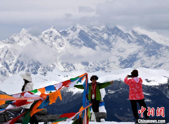 圖為5月14日，西藏林芝色季拉山觀景臺，游客與南迦巴瓦峰合影。　李林 攝