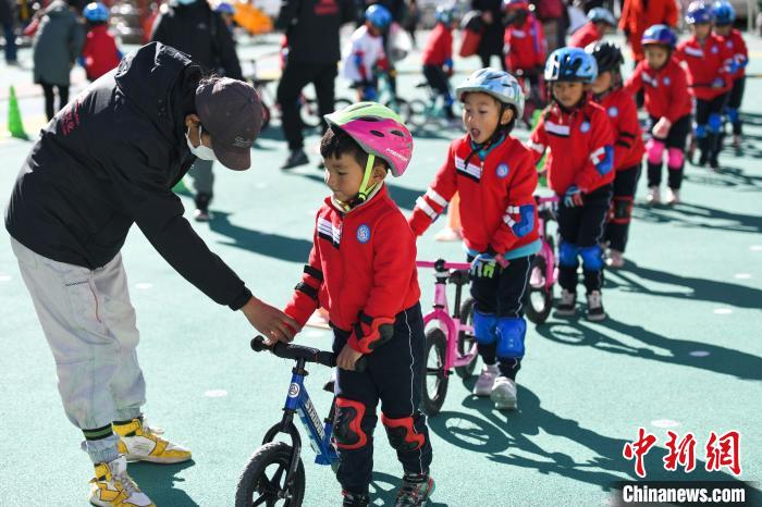 圖為拉薩市實驗幼兒園孩子們在教練的指導(dǎo)下練習(xí)滑步車。　何蓬磊 攝