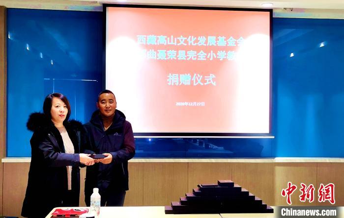 圖為西藏高山文化發展基金會理事長溫麗向聶榮縣完全小學負責人捐助儀器。　于賓 攝