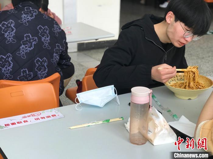 3月17日，西藏大學學生正在學校食堂用餐，餐桌上寫著“按需取餐，切勿浪費”。　冉文娟 攝