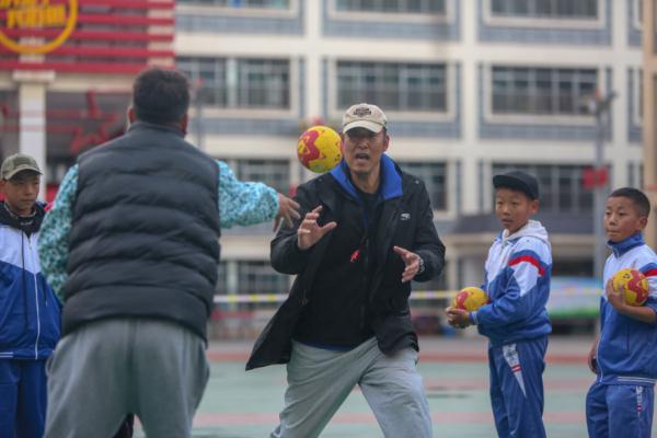 在高原上教孩子們打手球，“慢慢兒來，甭著急！”