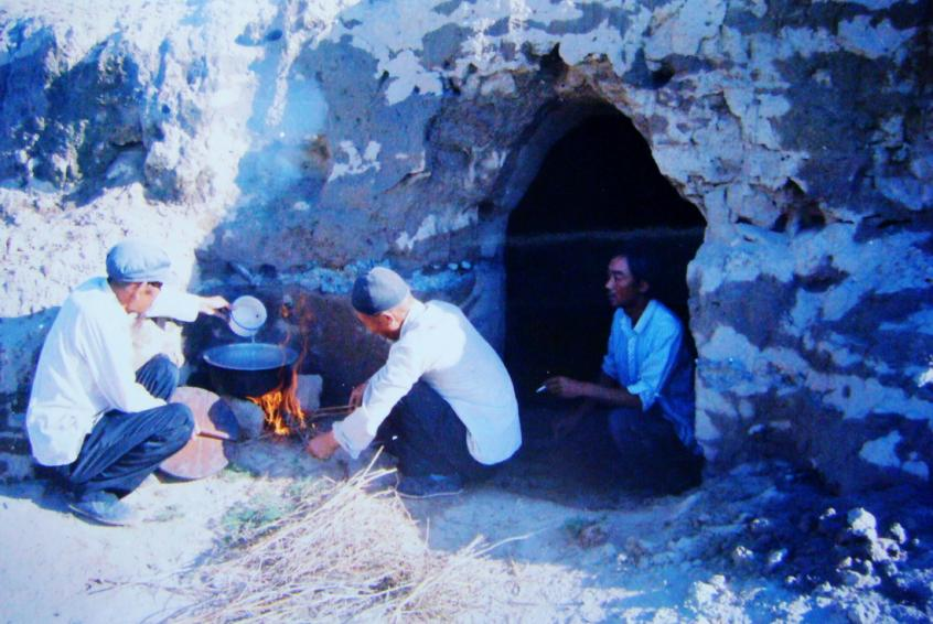 1983年，“六老漢”一代治沙人在“地窩子”生活做飯。新華社發(fā)（八步沙林場供圖）