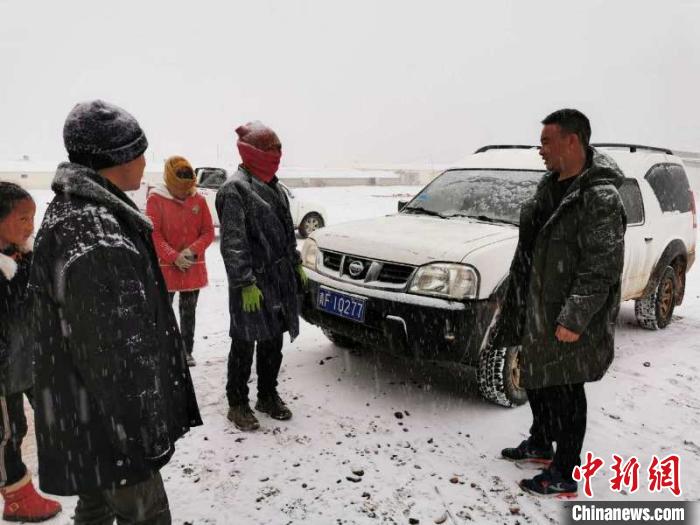圖為扎西鬧吾(右一)與當地牧戶交談。郵儲銀行青海省分行供圖
