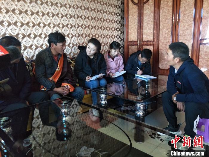 圖為調(diào)查組工作人員正在入戶調(diào)查。　祁增蓓 攝