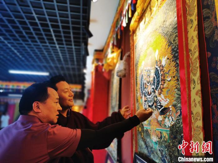 圖為久美尖措展示唐卡作品。　張?zhí)砀?攝
