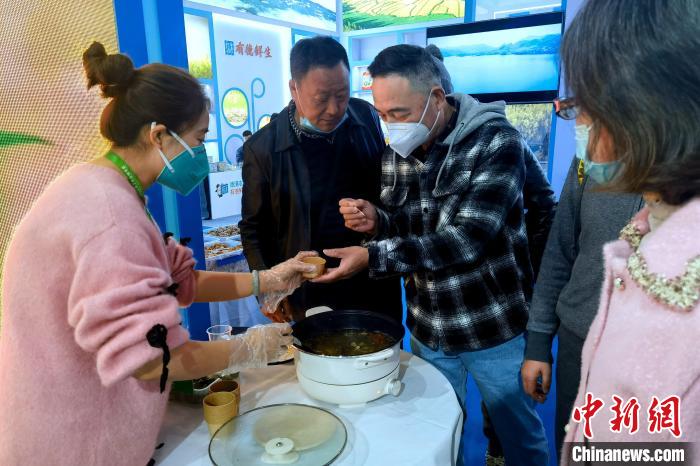 圖為杭州市民品嘗茶卡羊肉。　李雋 攝