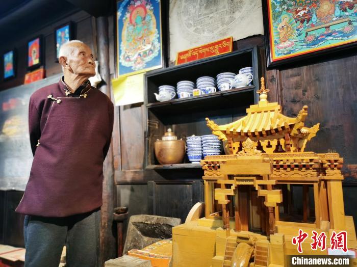 圖為古堡內(nèi)的藝人桑杰展示自己的雕刻作品。　張?zhí)砀?攝