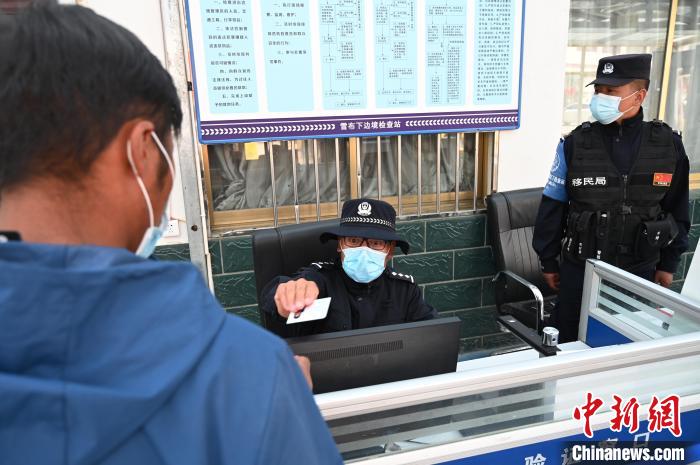 圖為移民管理警察登記完身份信息后將證件歸還給行人。　趙朗 攝