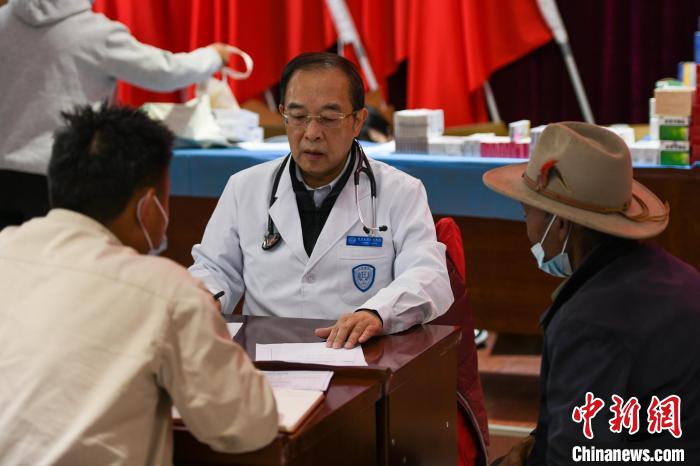 北京大學人民醫(yī)院心臟中心副主任、博士生導師王偉民為農牧民問診。　江飛波 攝