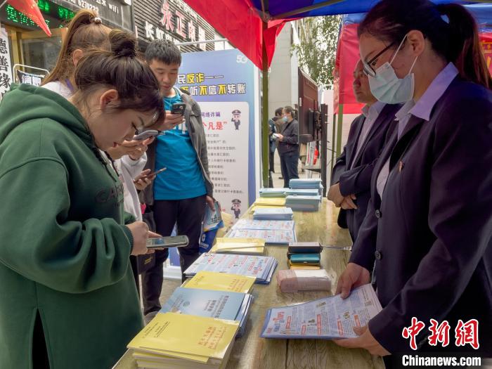 圖為工作人員正在向路過市民介紹國家反詐中心軟件的功能。　謝牧 攝