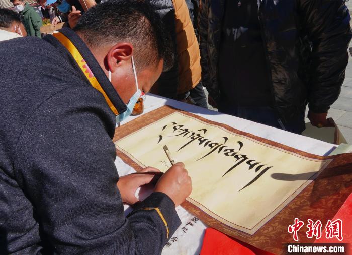 圖為書法家展示藏文書法?！∪轿木?攝