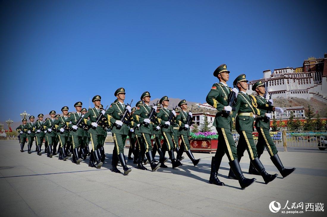 國旗護衛隊隊員緊握鋼槍，踏著威武雄壯的步伐，走向國旗臺。人民網 次仁羅布攝