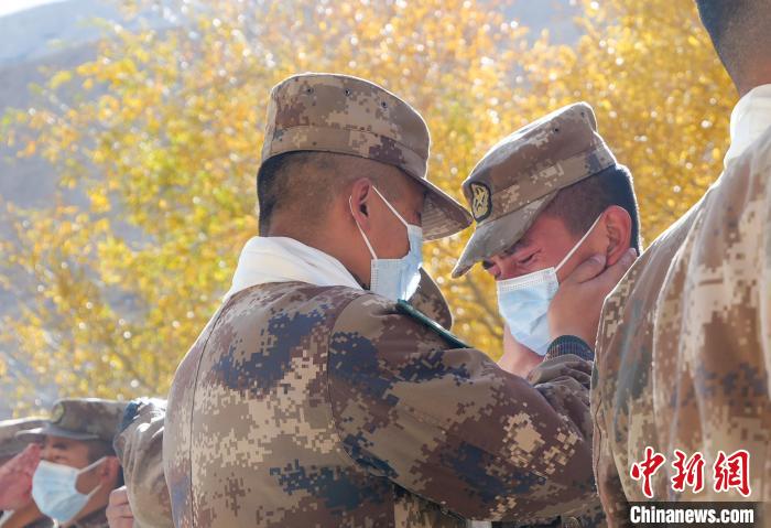 圖為什布奇邊防連退伍老兵與戰(zhàn)友相擁而泣，依依惜別。　徐昌成 攝