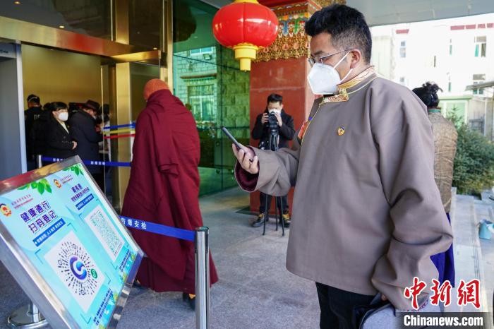 圖為政協(xié)委員掃場所碼進入會場。　江飛波 攝