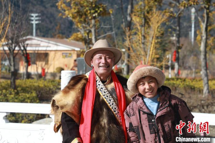 圖為林芝市巴宜區布久鄉仲果村村民桑杰與孫子一起參加藏歷新年活動?！埩?攝
