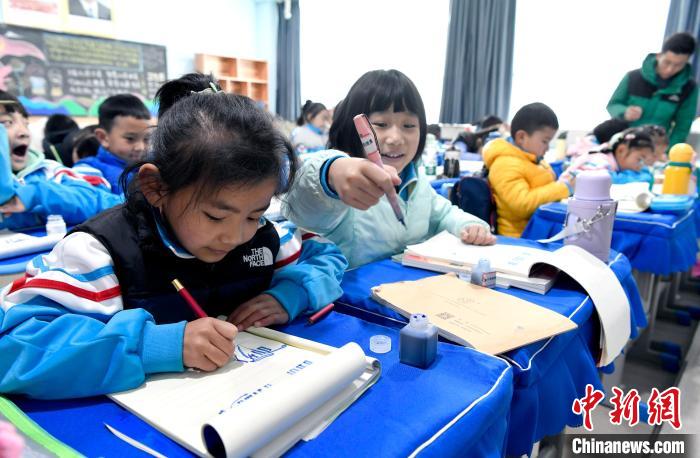 3月14日，西藏拉薩市第一小學一年級六班學生白瑪朗珍(圖左)在藏語文課上書寫藏文?！±盍?攝